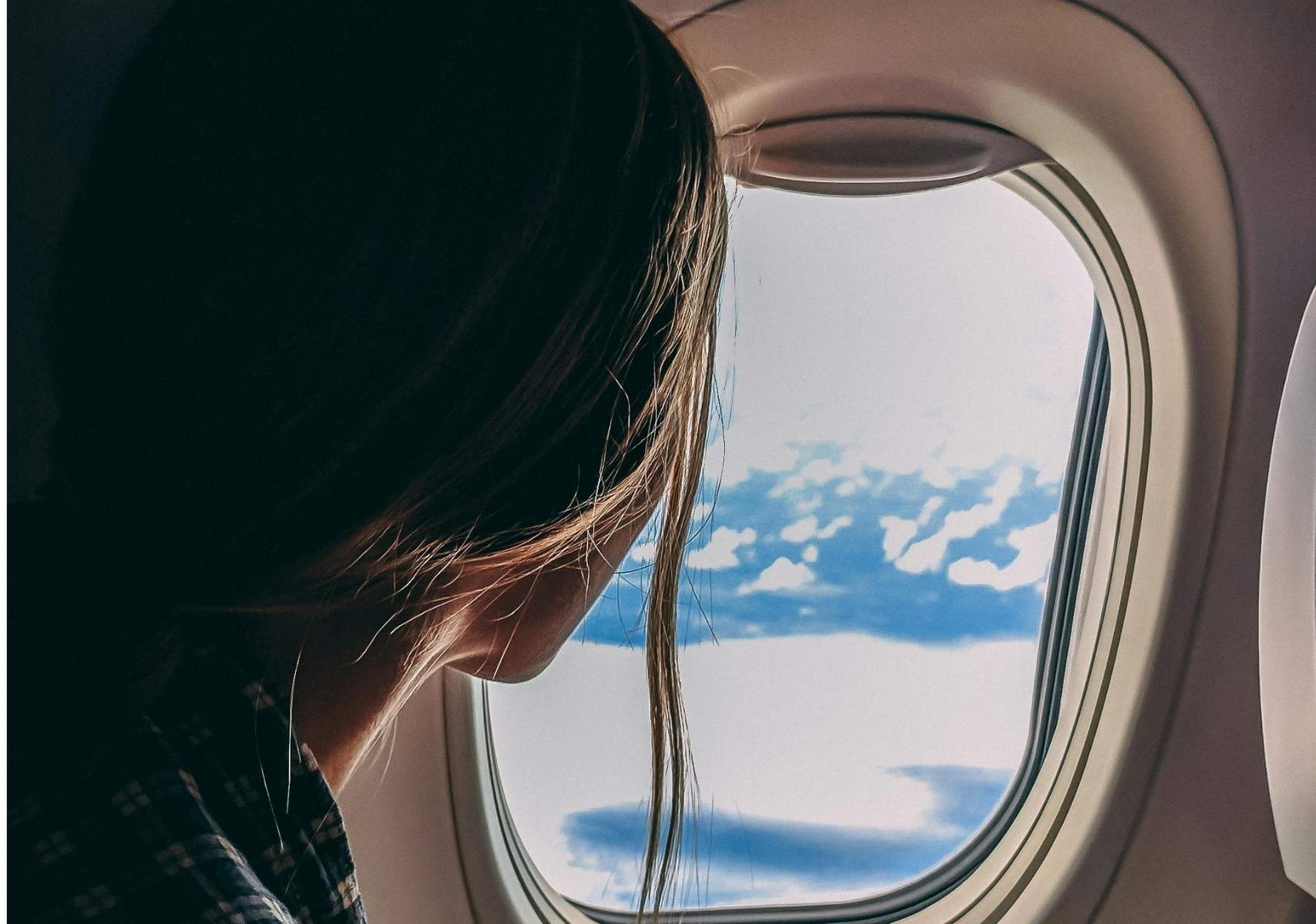 Mujer mirando por la ventanilla del avión