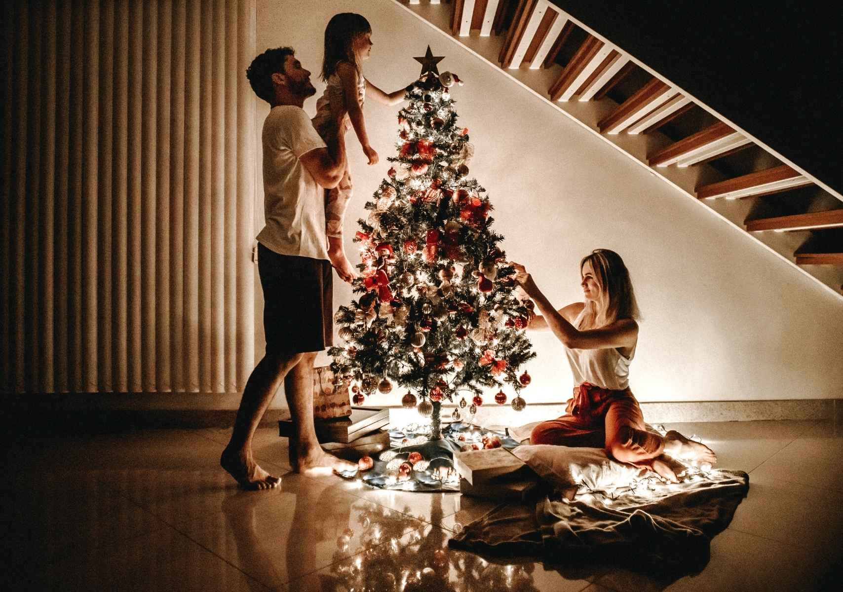 Pequeña Familia adornando su árbol de Navidad
