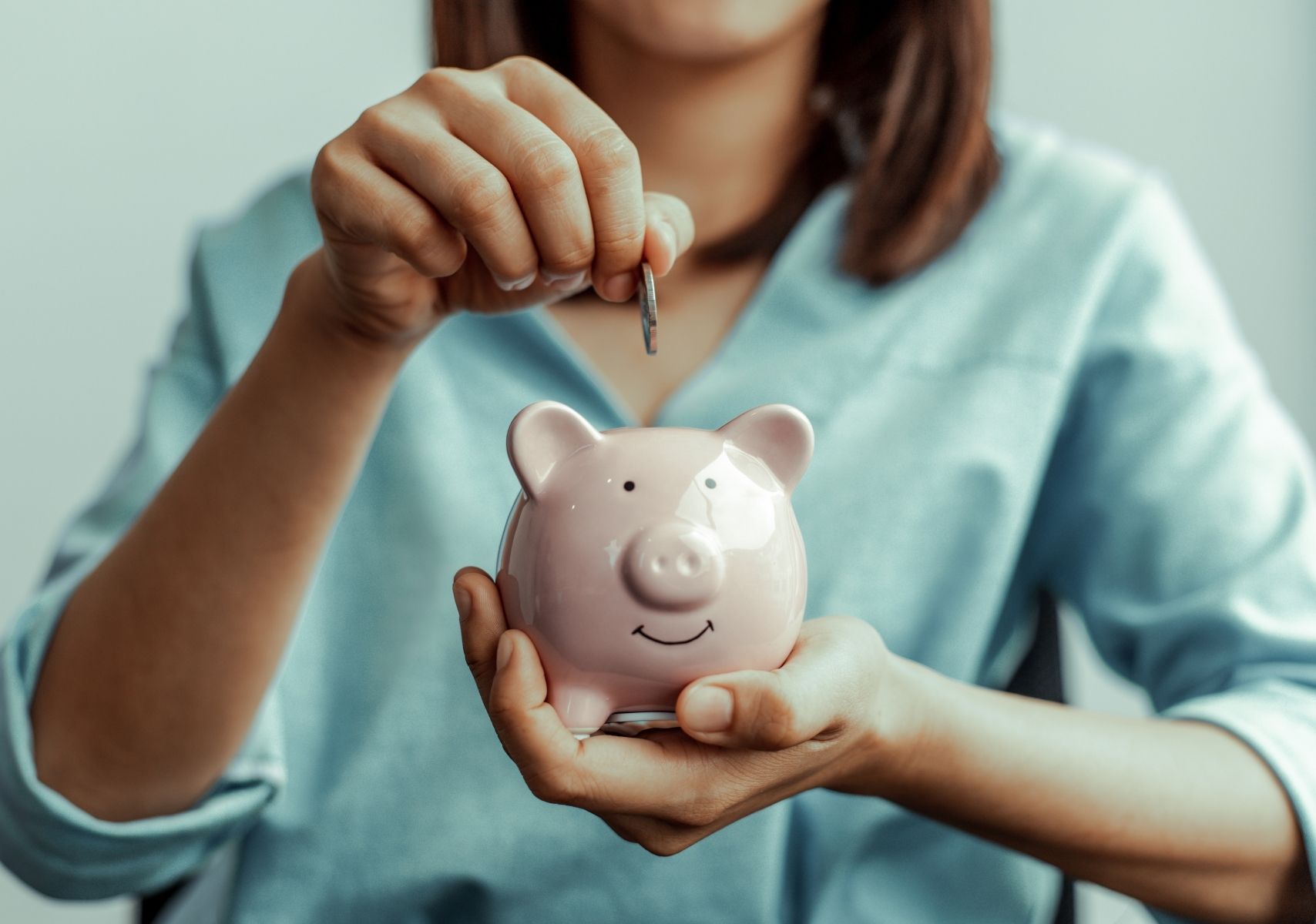 IA para organizar finanzas. Mujer ahorrando una moneda en un cochinito